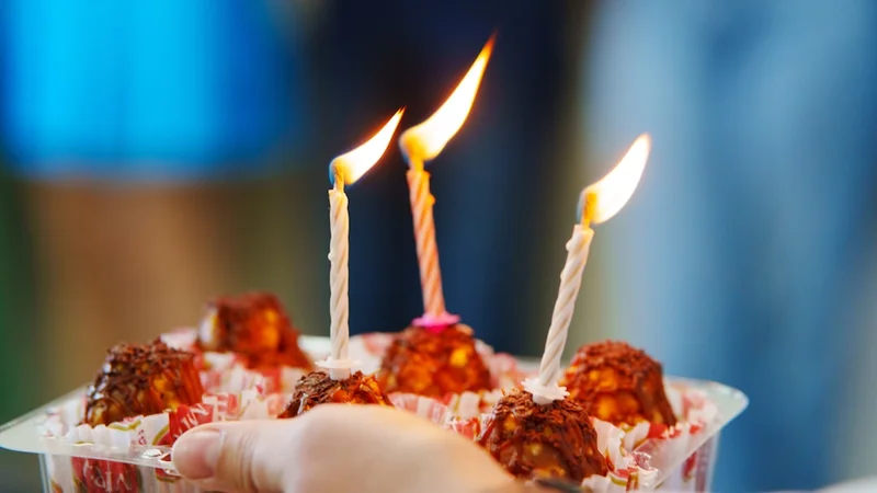 a person holding a plastic container filled with candles